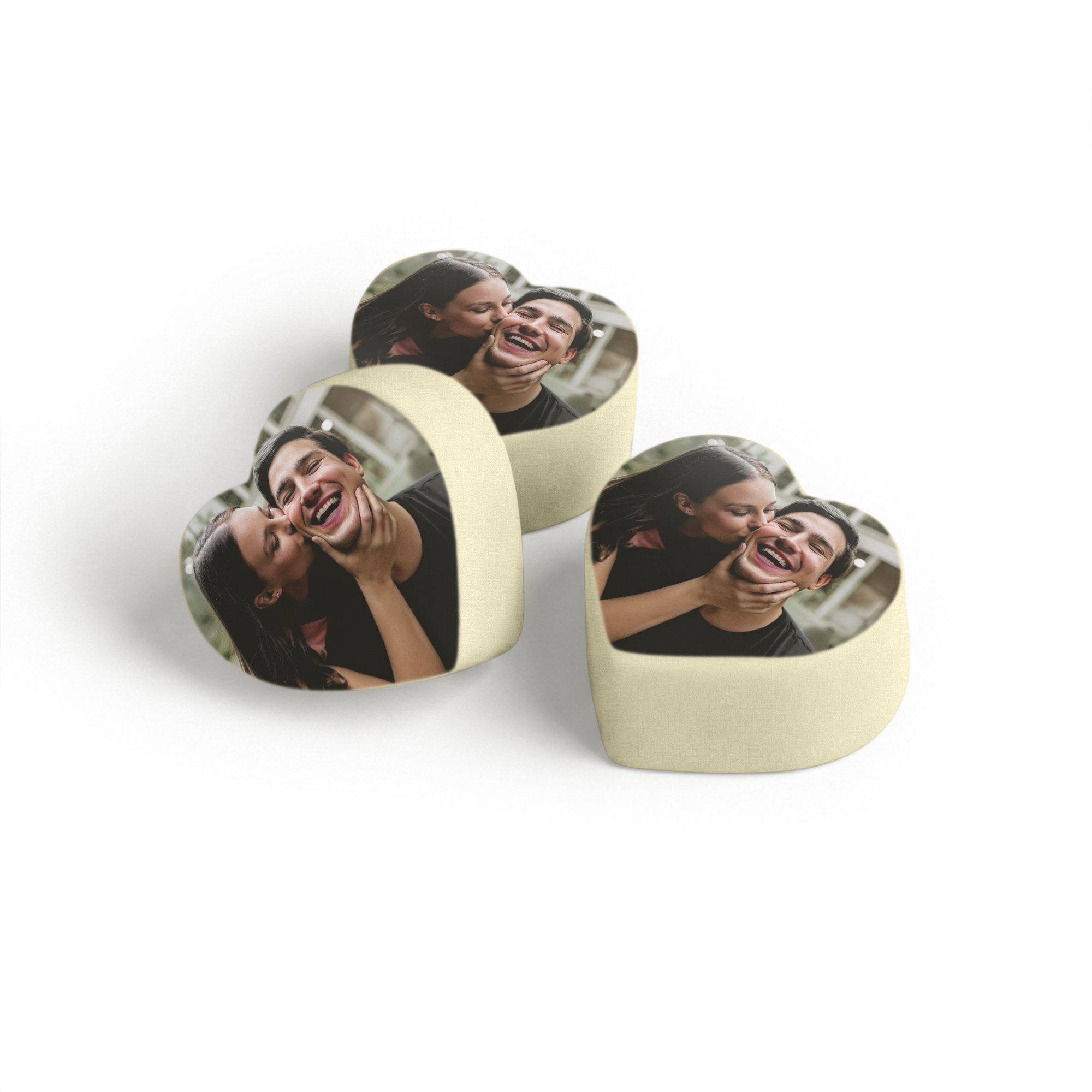 Hjerteformede personaliserede chokoladepraliner med et trykt foto af et smilende par.