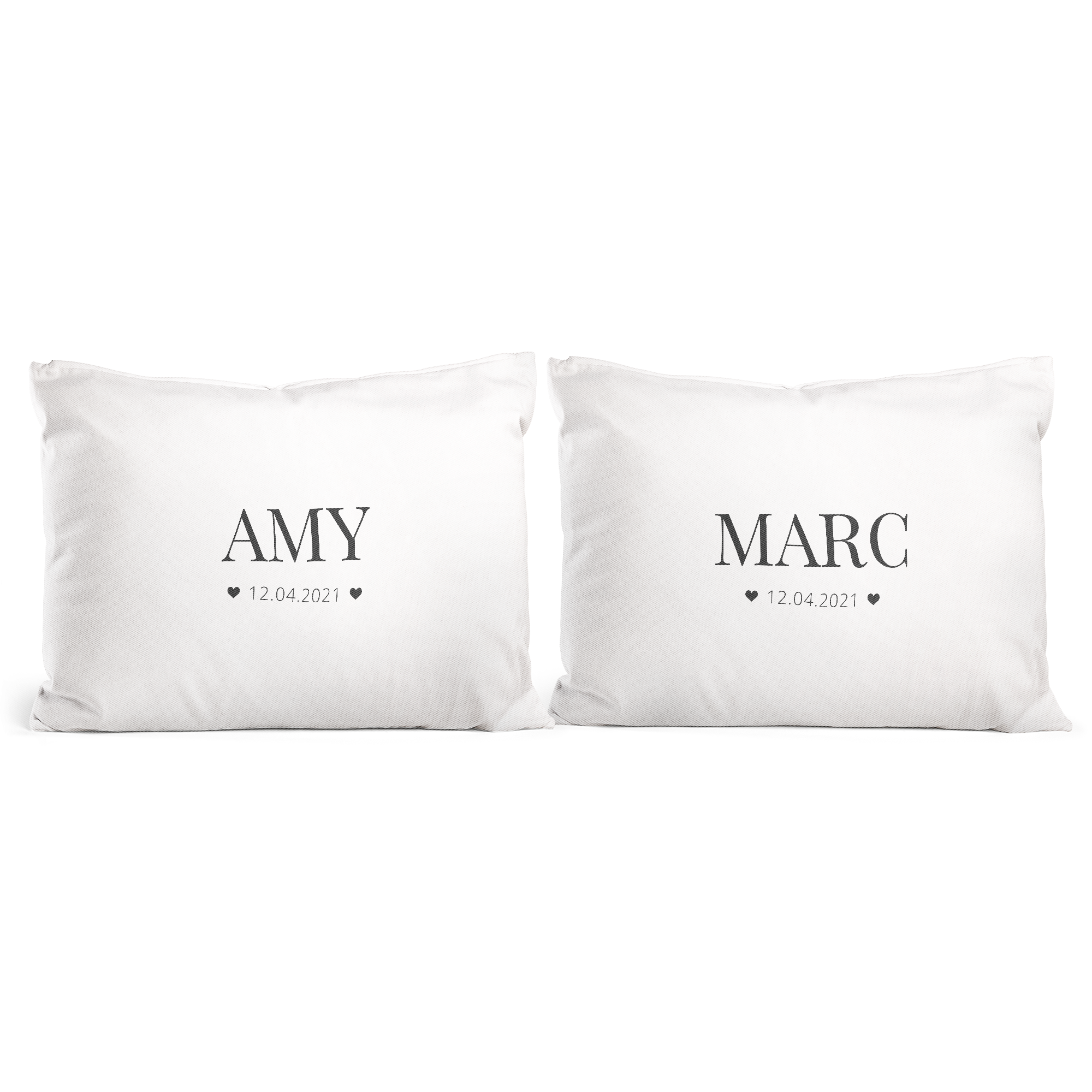 Zwei weiße Kissen für Paare mit individuellem Druck der Namen Amy und Marc und dem Datum 12.04.2021