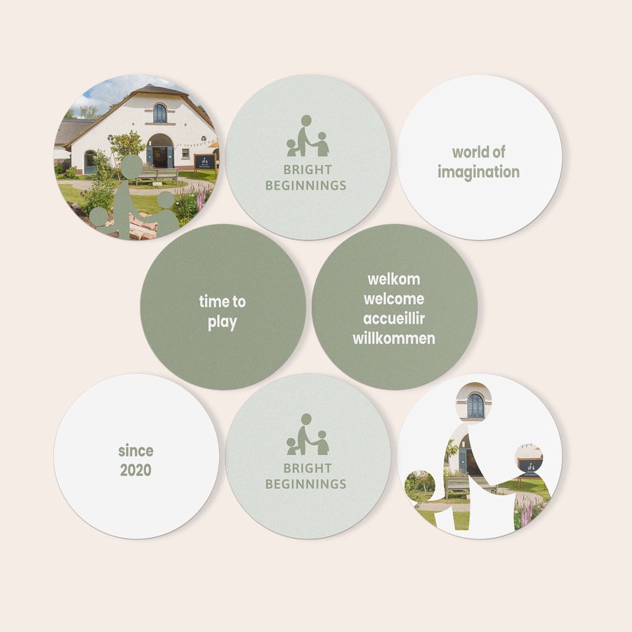 Azulejos personalizados Nueve paneles de arte en forex redondos, personalizados con fotos, logos y texto como "since 2020", "world of imagination" y "bright beginnings" en una pared negra.