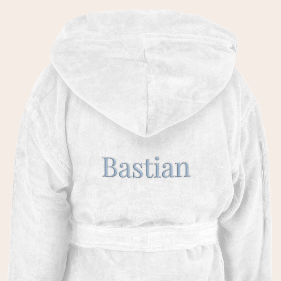 Badekåbe - børn Hvid morgenkåbe til børn broderet med navnet Bastian på ryggen. Overrask med en dejlig blød morgenkåbe til børn med eget navn.