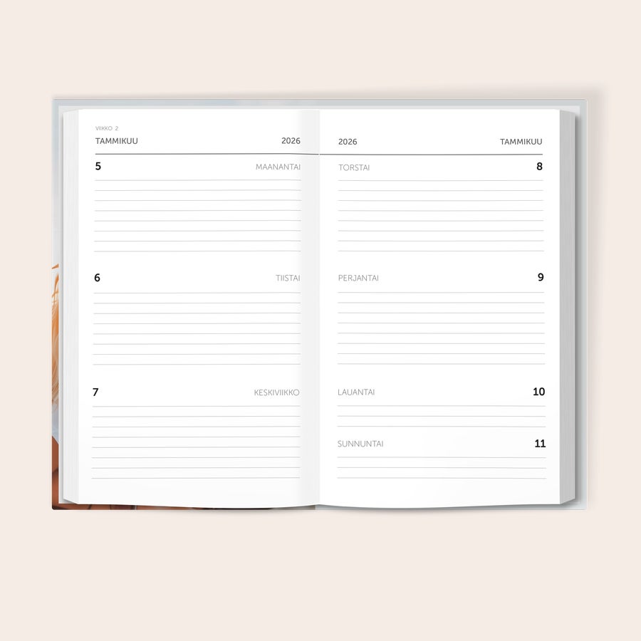 Vuosikalenteri 2026 Auki oleva yksilöllinen päiväkirja, jossa näkyvät tammikuun 2026 päivät 5-11 ja tekstit "MAANANTAI" "TIISTAI" "KESKIVIIKKO" "TORSTAI" "PERJANTAI" "LAUANTAI" ja "SUNNUNTAI".