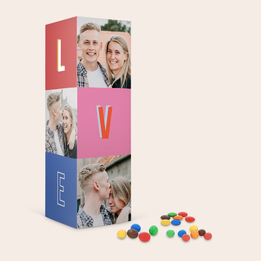 Personalizovaná M&M's dárková krabička Personalizovaná dárková krabička M&M's s potiskem fotografií a nápisem LOVE, barevné bonbony M&M's vysypané na stole. Překvapte své blízké M&M's v personalizované dárkové krabičce.