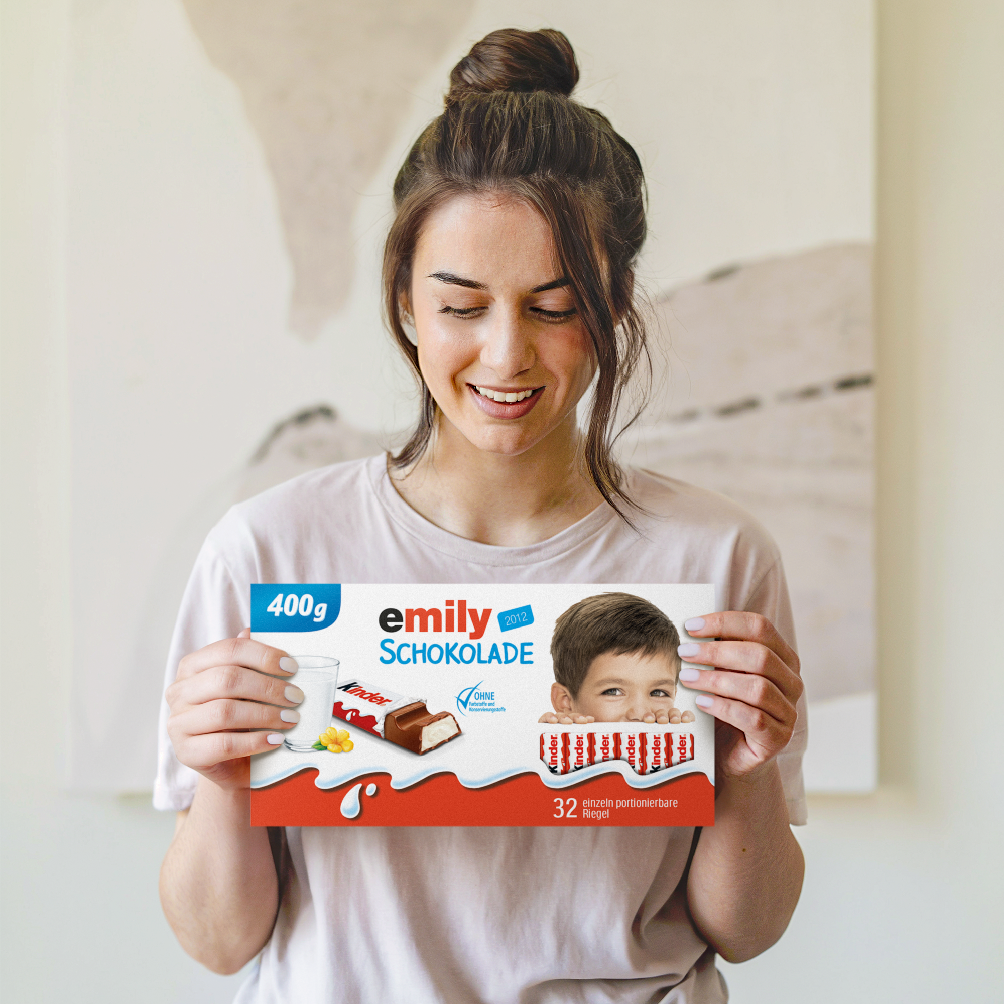 Eine Frau hält eine Mega kinder Schokolade mit Namen - 400 Gramm mit personalisiertem Namen Emily und Kinderfoto auf der Verpackung.