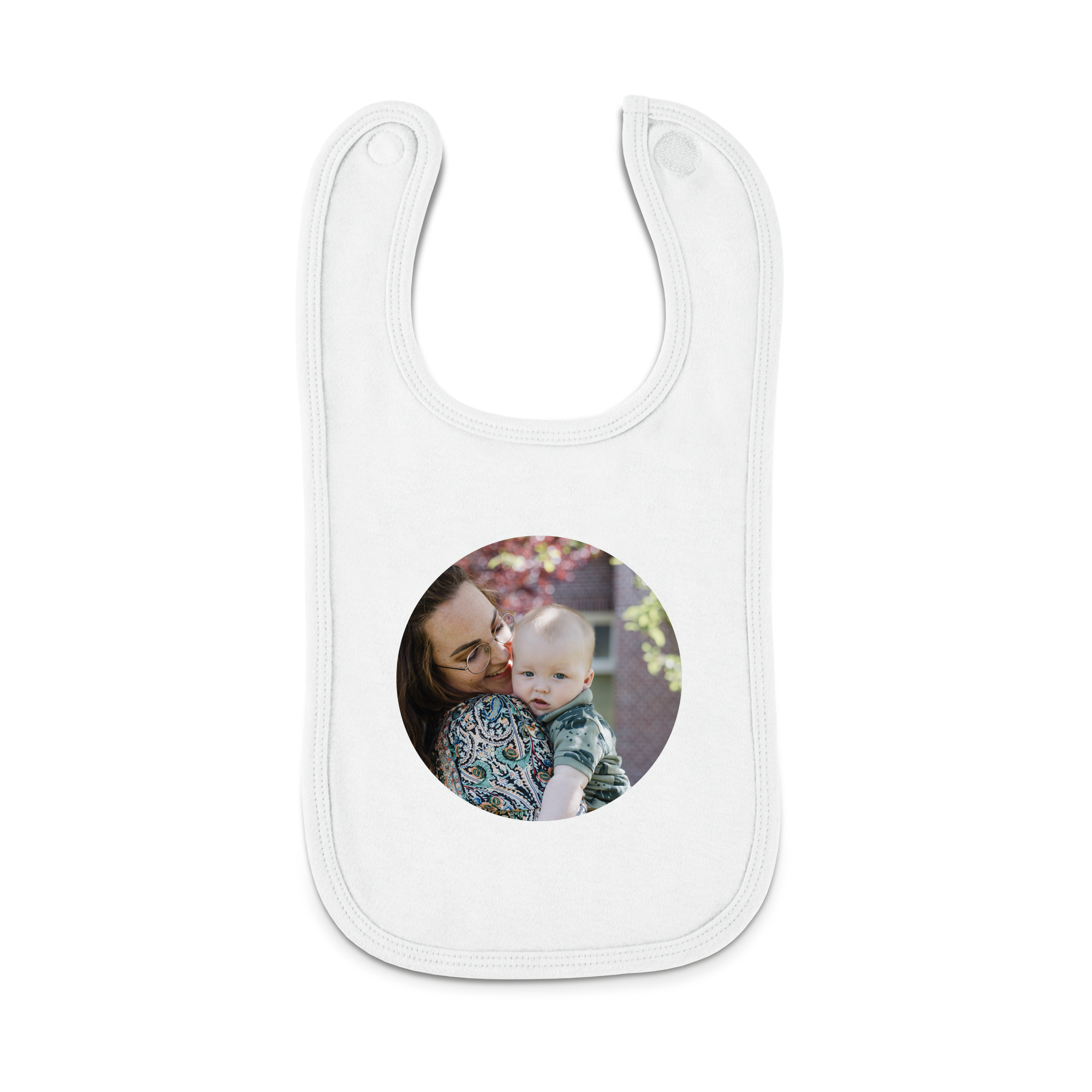 Hvit babybib med trykt bilde av en mor som holder barnet sitt.