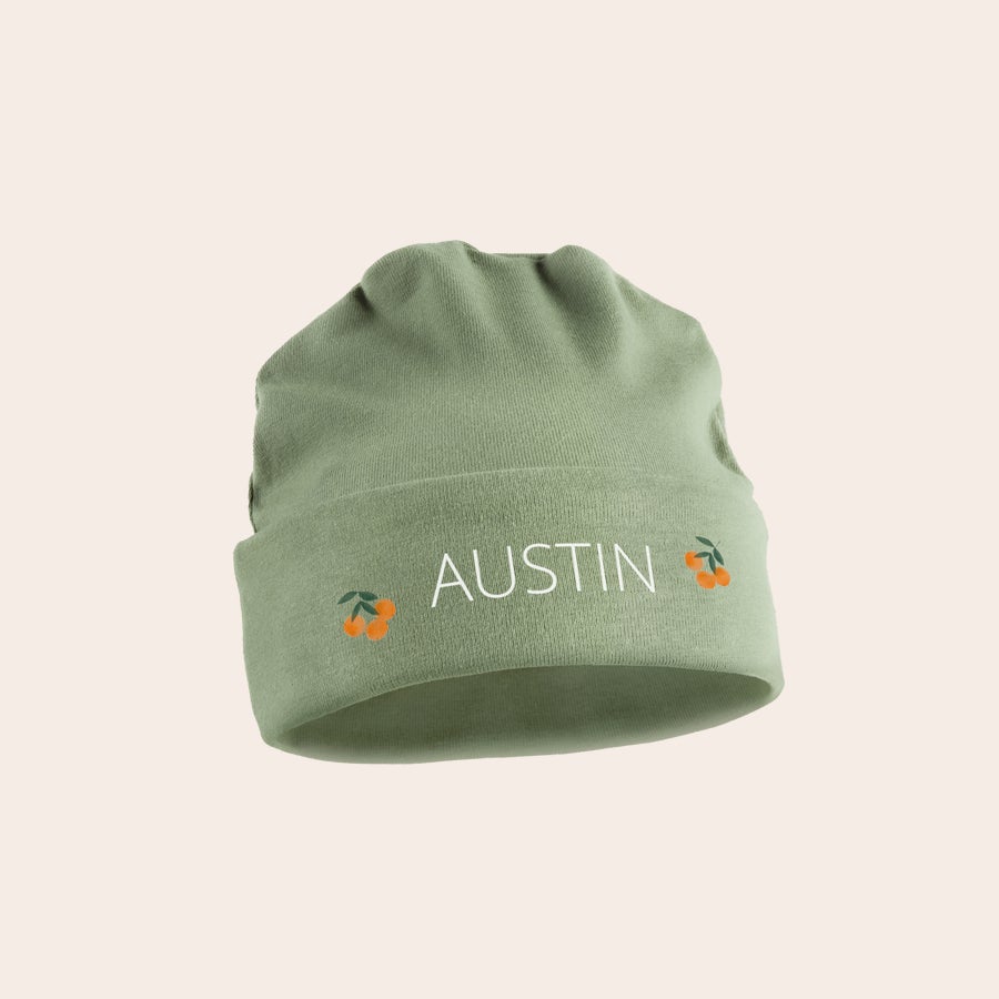 Gorrito de bebé Gorro de bebé verde personalizado, estampado con el nombre "Austin" y cerezas naranjas.