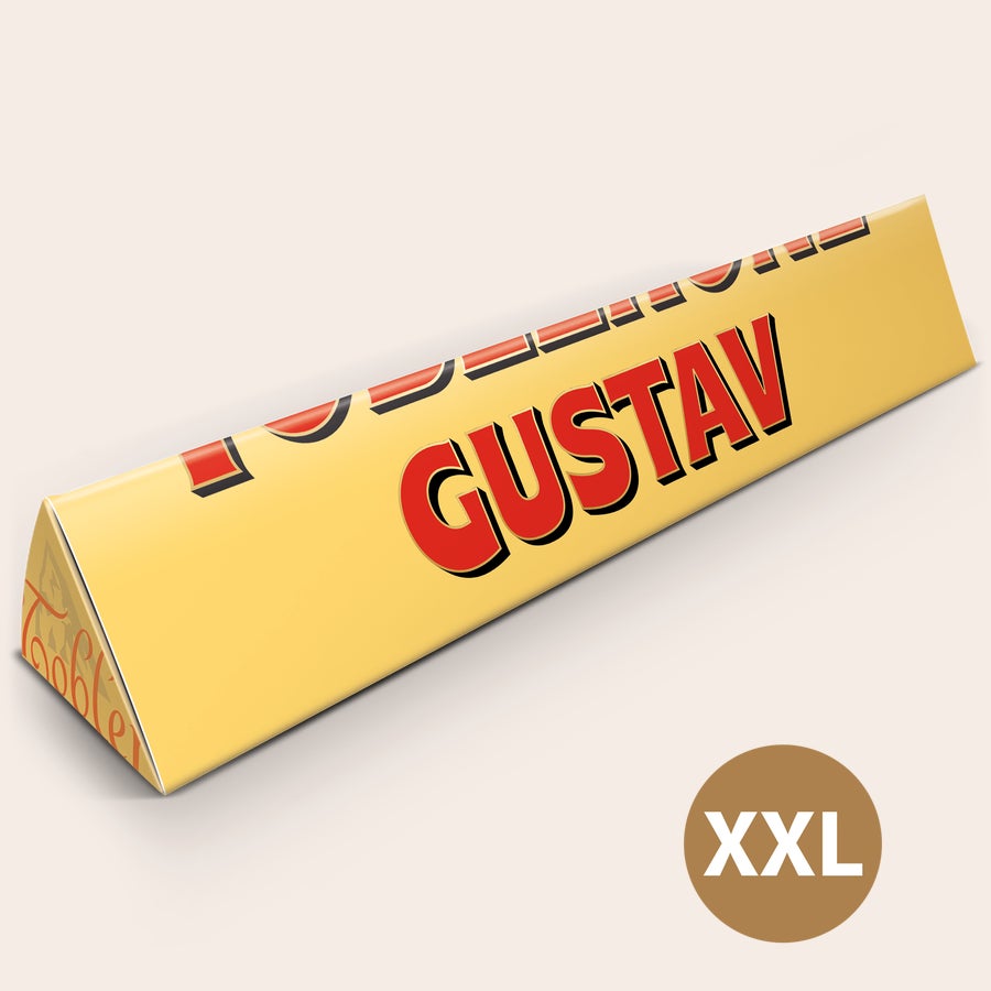 Toblerone XXL med namn En personaliserad Toblerone XXL med namnet "GUSTAV" tryckt i rött och svart på den gula förpackningen