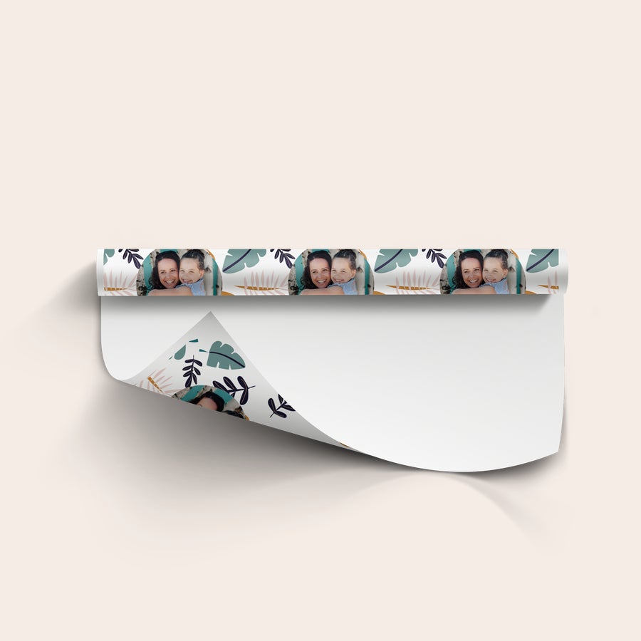 Gepersonaliseerd inpakpapier met eigen foto Gepersonaliseerd cadeaupapier met een herhalend patroon van een moeder en dochter foto en tropische bladeren, wit opgerold
