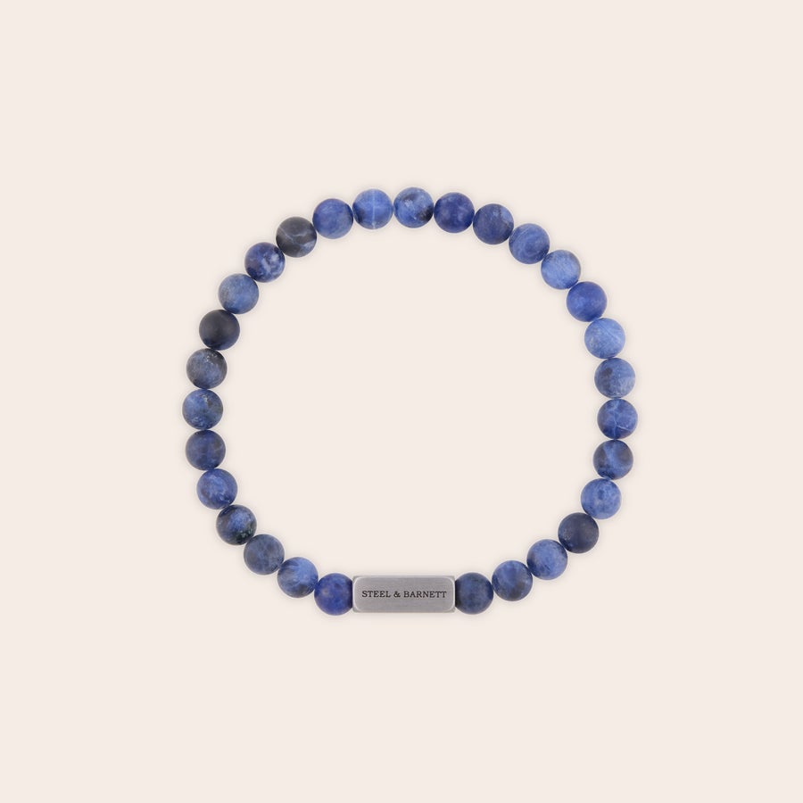 Brățară personalizată cu pietre prețioase Brățară personalizată Steel & Barnett, cu mărgele albastre mat și o placă metalică gravată cu numele dorit.