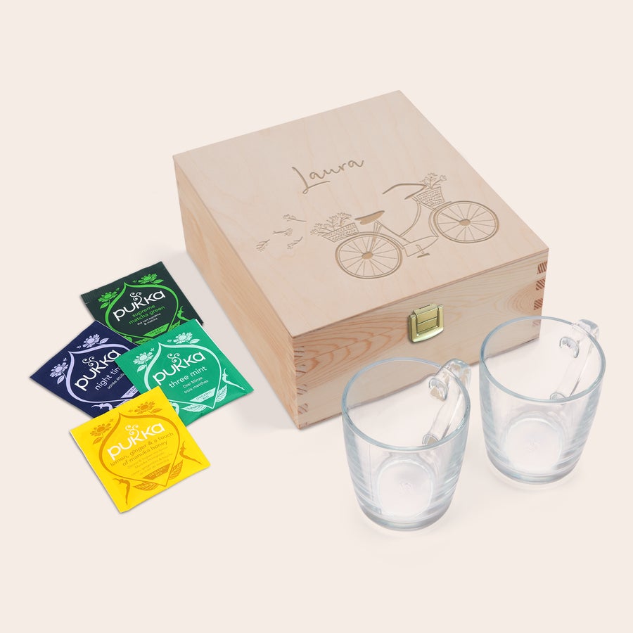 Tebox Överraska dina nära och kära med en graverad teask, Pukka-te och två glas. Teasken har namnet Laura och en cykel graverad på locket.