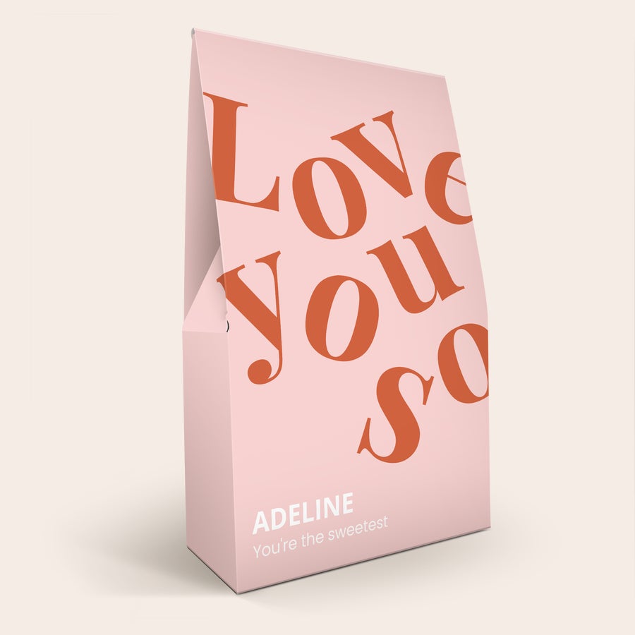 XL Haribo édesség ajándékdoboz Személyre szabott XL Haribo édesség-ajándékdoboz pasztell rózsaszín alapon "Love You So" szöveggel és "Adeline You're the sweetest" felirattal, színes nyomtatással