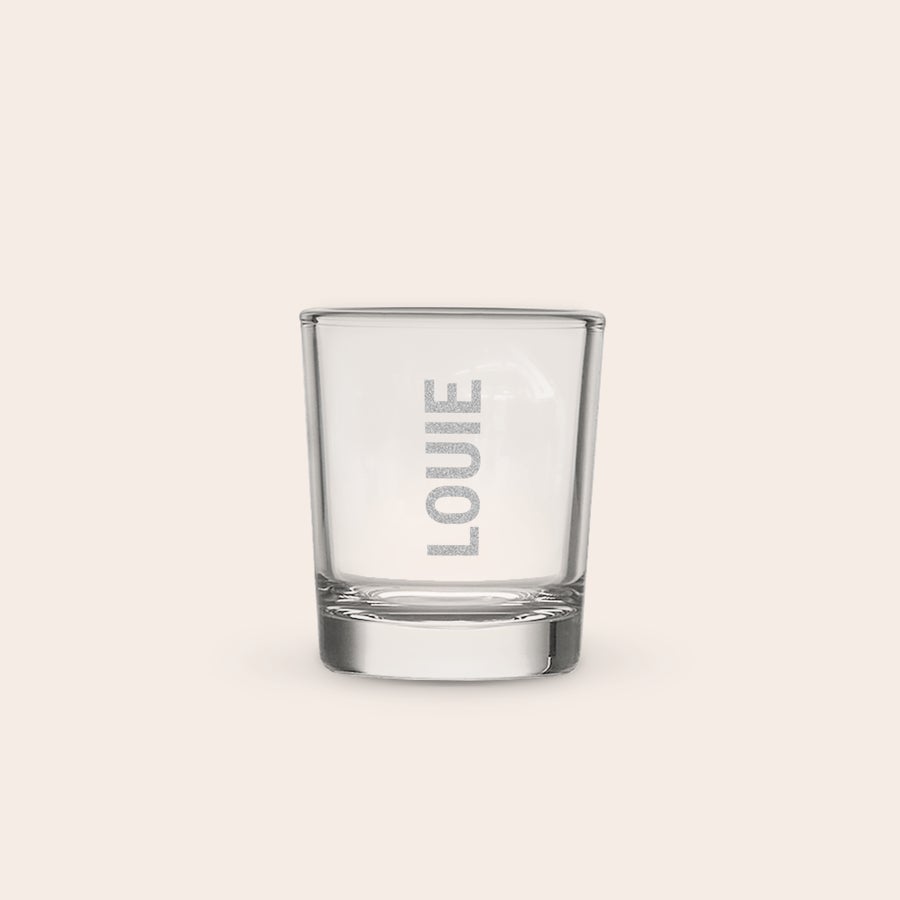 Shotglas Et personligt indgraveret shotglas med navnet "LOUIE" og en isterning indeni, perfekt til en blast.