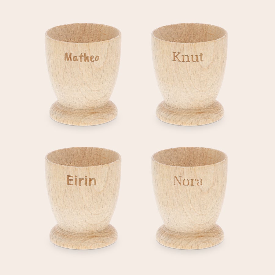 Personlig eggebeger Personlige eggekopper i bøk, gravert med navnene Matheo, Knut, Eirin og Nora. Gjør frokosten minneverdig.
