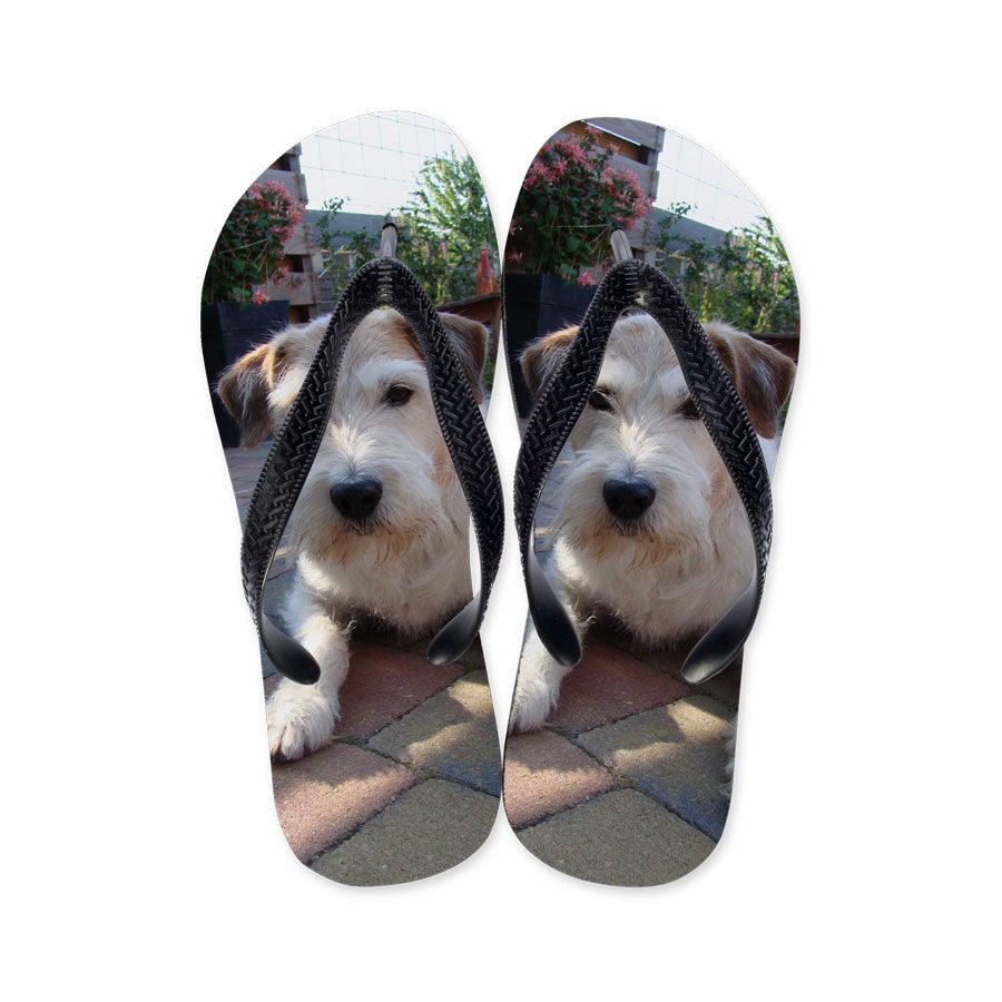 Individuelle Zehensandalen als Geschenk, bedruckt mit einem Foto eines liegenden Hundes auf Pflastersteinen.