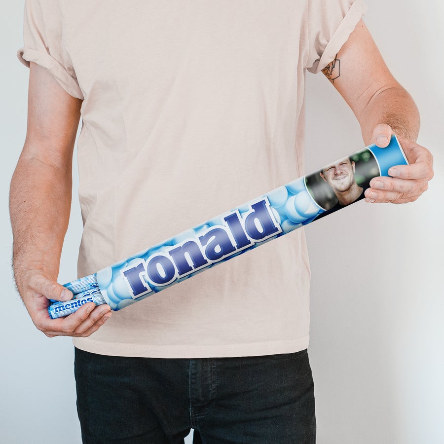 Jätti-Mentos kuvalla ja/tai tekstillä Henkilö pitää kädessään Mentos XXL-lahjaa omalla kuvalla ja nimellä Ronald, raikas Mentos-lahja