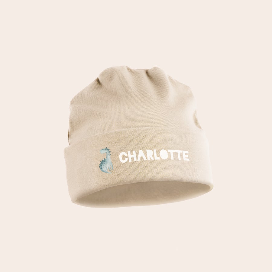Chapéu de bebê Gorro creme para bebé estampado com um dinossauro e o nome Charlotte, um gorro totalmente personalizado.