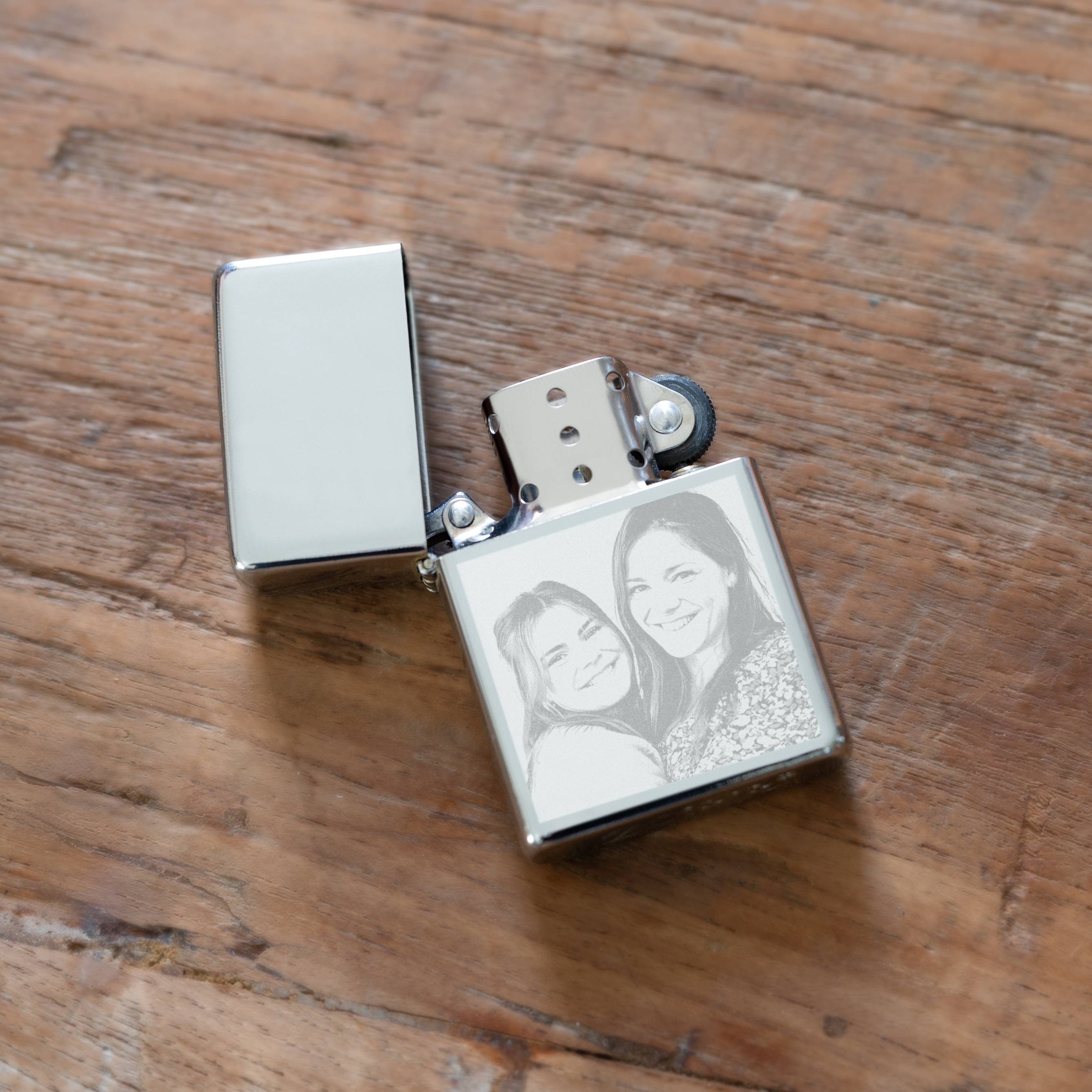 Luksus lighter med gravering og foto af to kvinder, åben på et træbord. Hvem overrasker du med den?