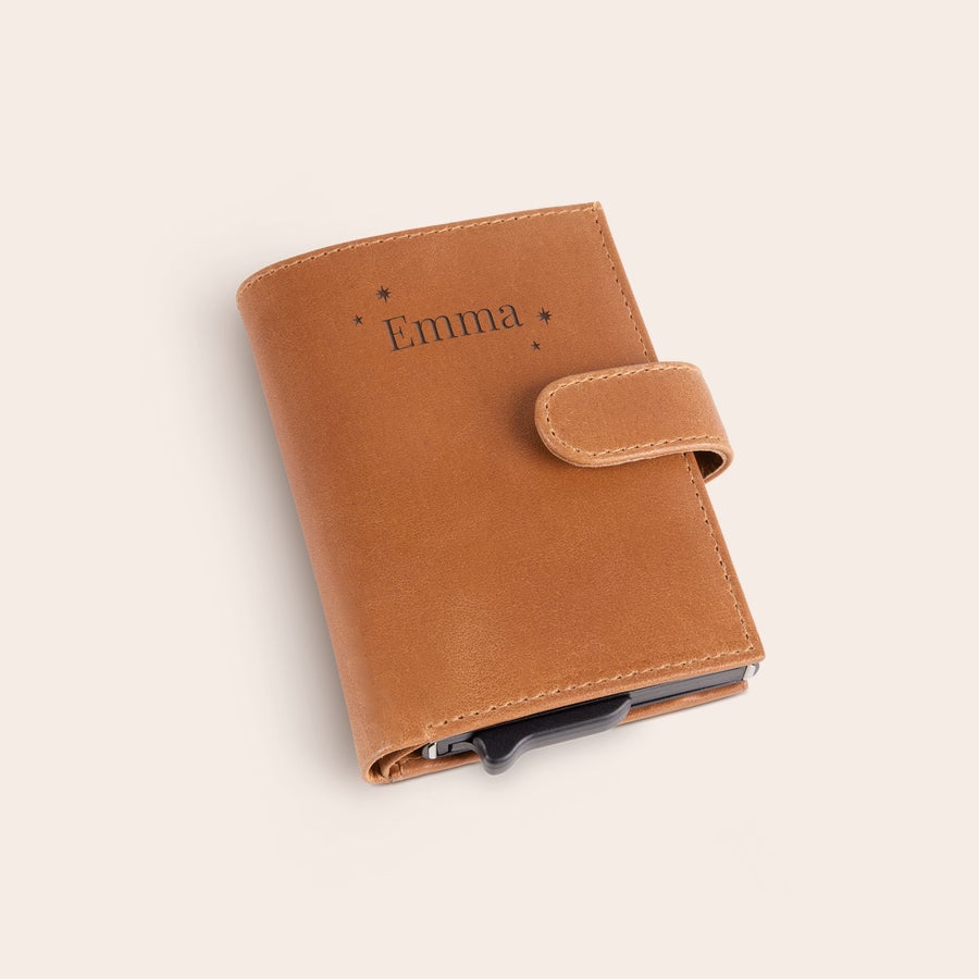 Personalizowany portfel na karty Brązowe etui na karty z grawerowanym imieniem "Emma" i gwiazdkami, z zapięciem i mechanizmem na karty.