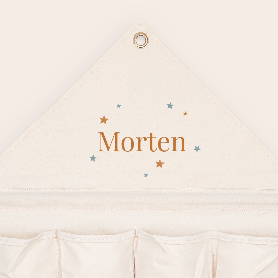 Hængende opbevaring med navn og/eller billede Personliggjort hængende opbevaring med navnet Morten og stjerner trykt på lommen.