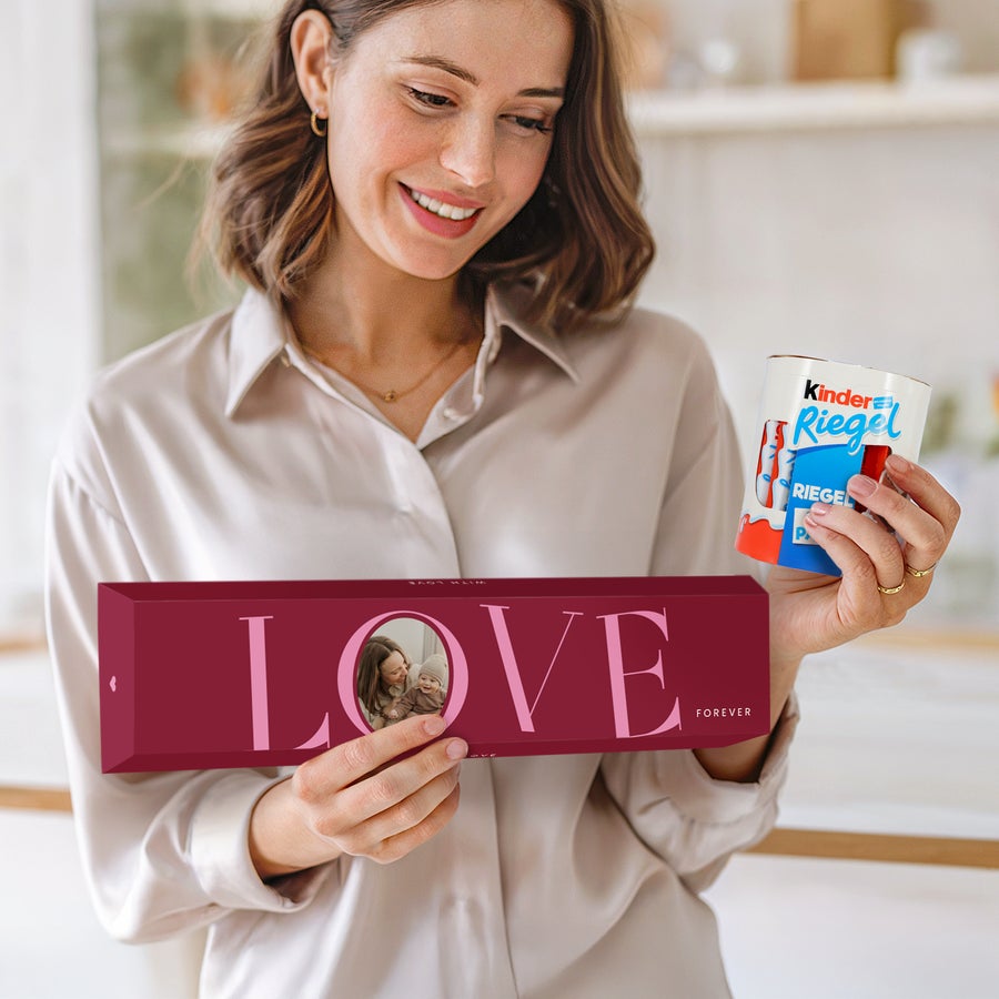 Personalisierte XXL-kinder Riegel Frau hält eine personalisierte XXL kinder Riegel Box mit Foto und eine Packung kinder Riegel zum XXL kinder Riegel personalisieren