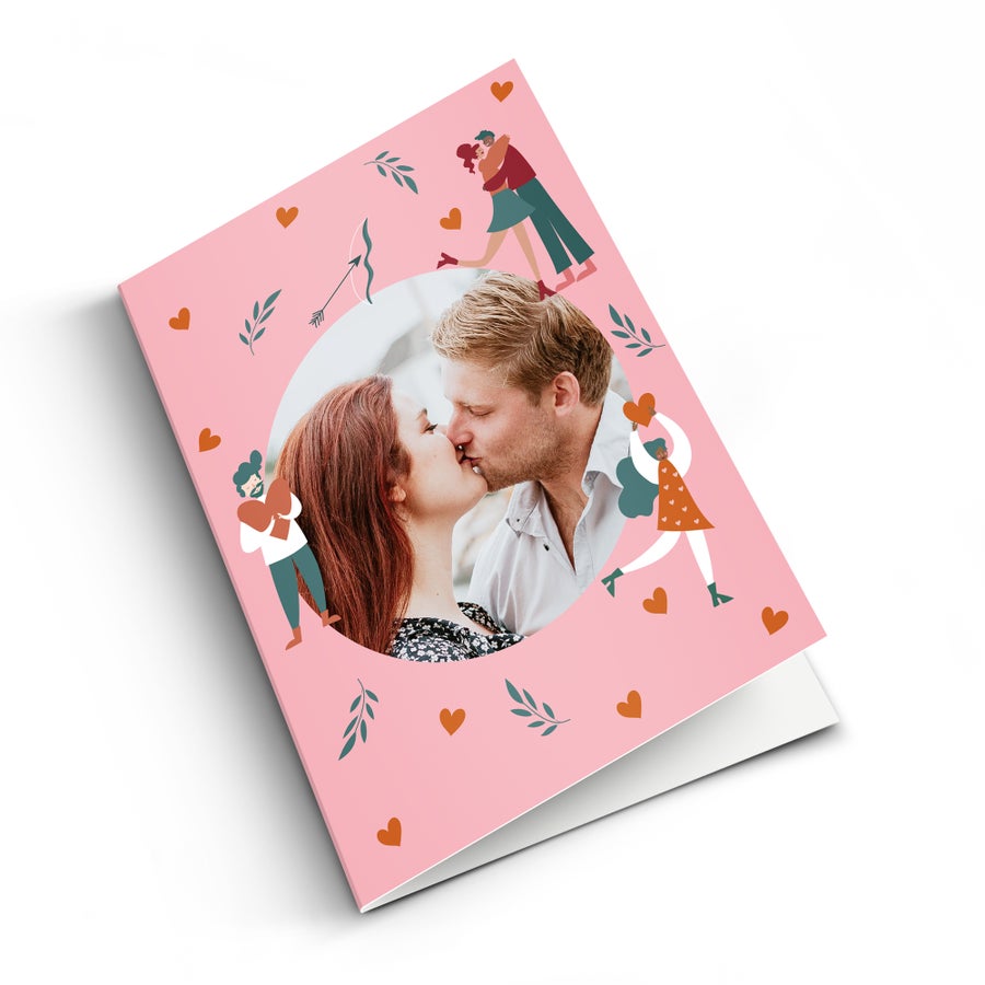 Valentínska karta s originálnym dizajnom tlačená s osobnou fotografiou zamilovaného páru, obklopená ilustráciami srdiečok, šípov a listov