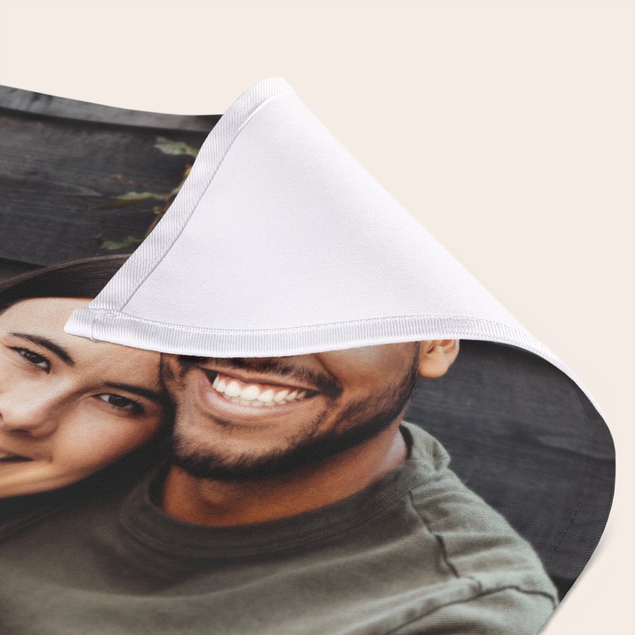 Přizpůsobené ubrousky Detail tištěného ubrousku s fotografií páru, na níž se usmívají, pro jedinečné nastavení stolu.