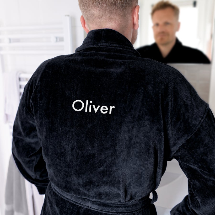 Personalizowany szlafrok męski z imieniem Mężczyzna w czarnym szlafroku z wyhaftowanym imieniem Oliver, kogo zaskoczysz luksusowym personalizowanym szlafrokiem