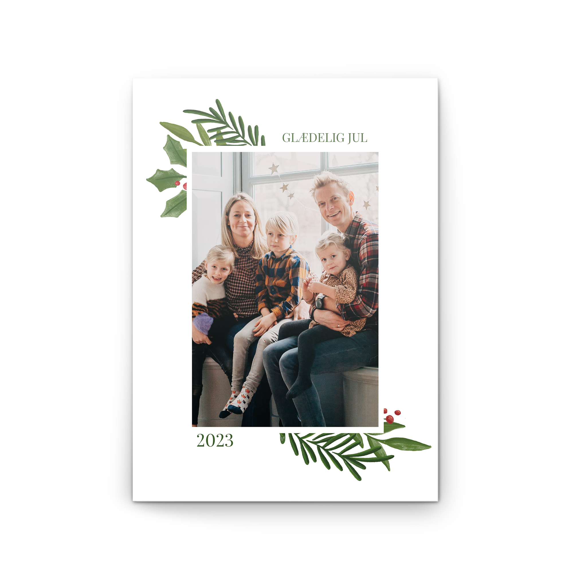 Et personligt lykønskningskort med foto trykt med "Glædelig jul" og en familiefotografering fra 2023.