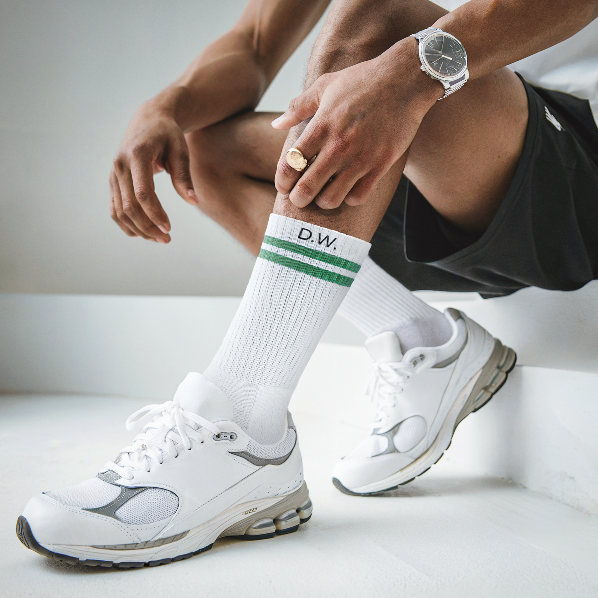 Șosete sport albe cu dungi verzi și inițialele D.W. personalizate printate, purtate cu pantofi sport albi.