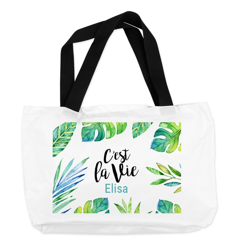 Bolsa de praia personalizada branca com alças pretas, estampa de folhas tropicais e o nome Elisa