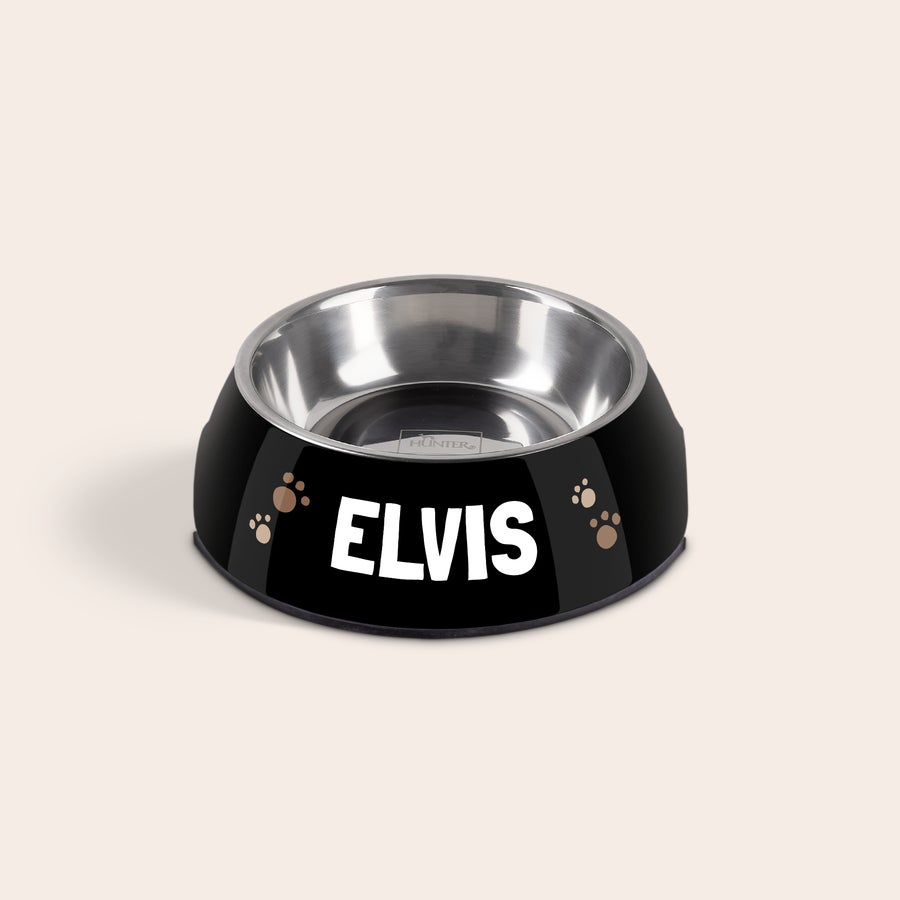 Hondenvoerbak met naam Zwarte roestvrijstalen hondenvoerbak met de naam Elvis en pootafdrukken geprint. Een persoonlijke hondenvoerbak met naam.