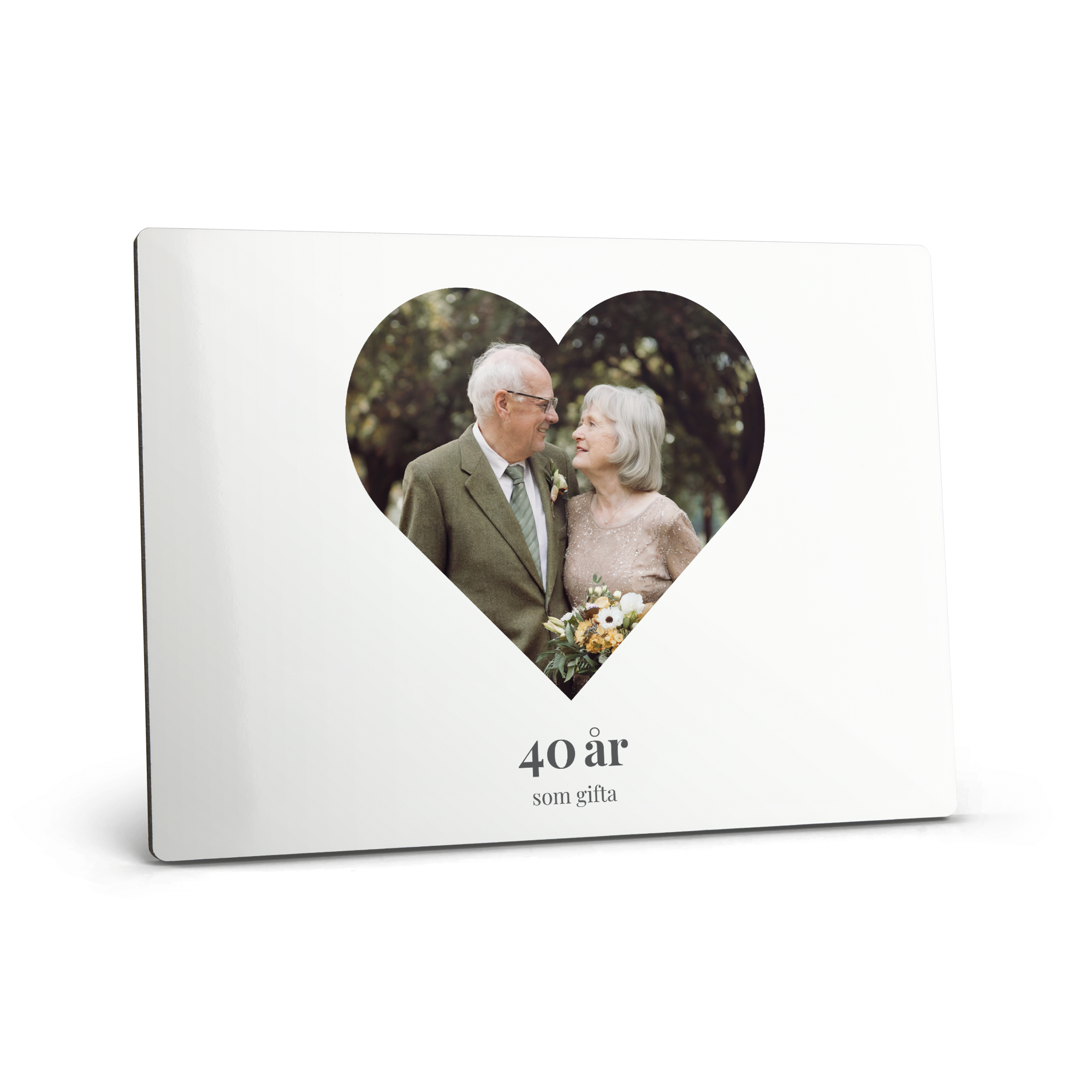 Vitt fotostativ med tryckt bild av ett äldre par, texten "40 år som gifta" och möjlighet att få din bästa bild tryckt.