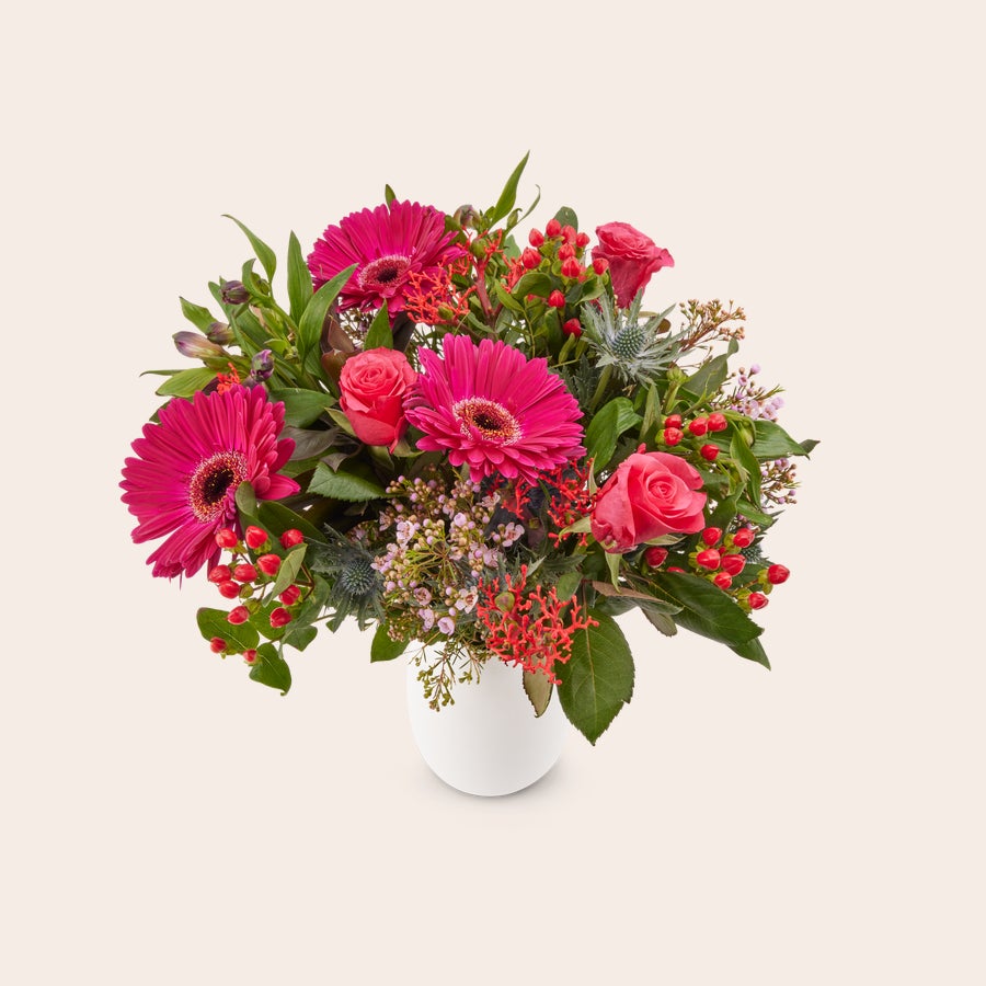 Blumenstrauß Lila Wunderschöner lila Blumenstrauß mit lila Gerbera, rosa Rosen, roten Beeren und grünen Blättern in einer weißen Vase, personalisierbar mit gratis Geschenkkarte