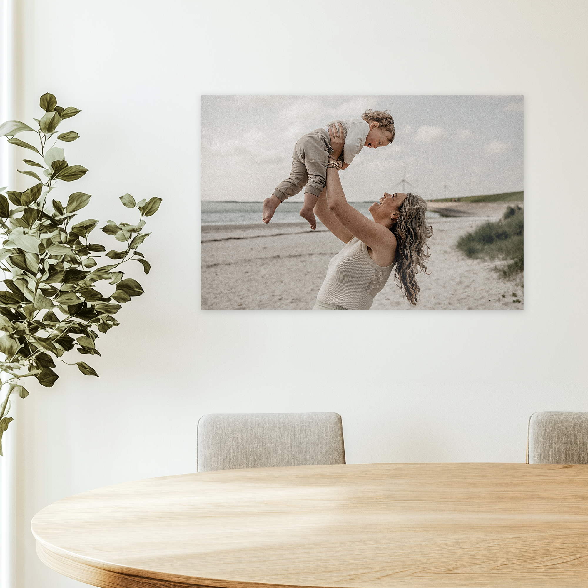 Foto en forex personalizada con la imagen de una madre levantando a su bebé en la playa.