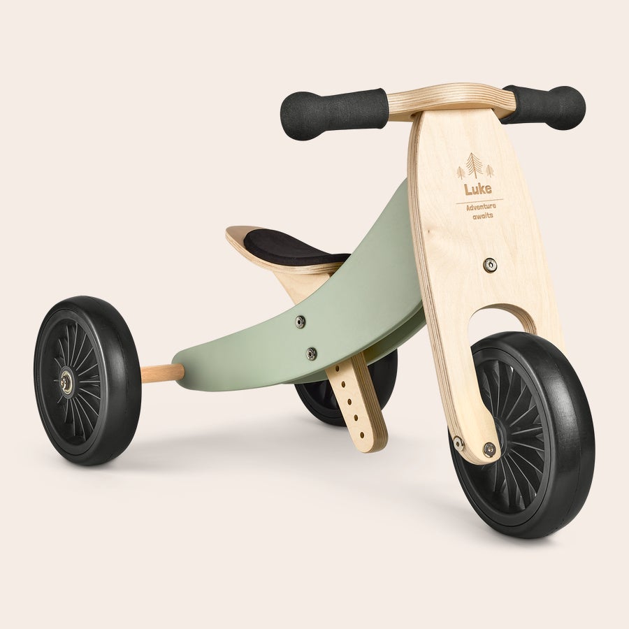 Triciclo in Legno Inciso  Triciclo in legno naturale e verde chiaro, inciso con il nome Luke e la scritta Adventure awaits, con ruote nere. Sfreccia su questo super triciclo personalizzato con nome