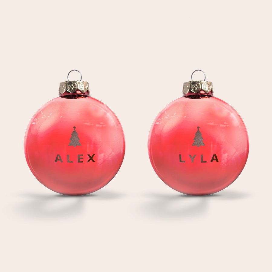 Vianočné gule - sklenené Dve červené vianočné gule zo skla, laserom gravírované s menami Alex a Lyla a vianočným stromčekom, perfektné na personalizované vianočné gule.