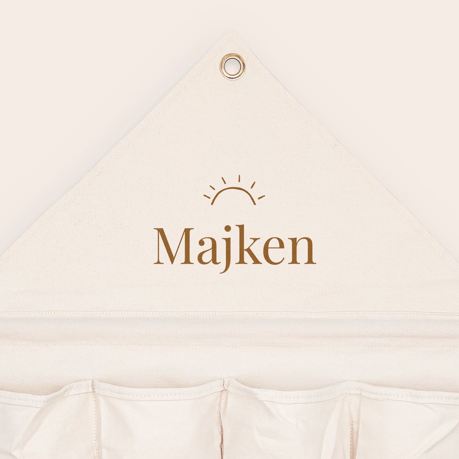 Organizer för fickor i tyg Beige personlig fickorganisator i tyg med texten Majken och en sol-ikon tryckt.