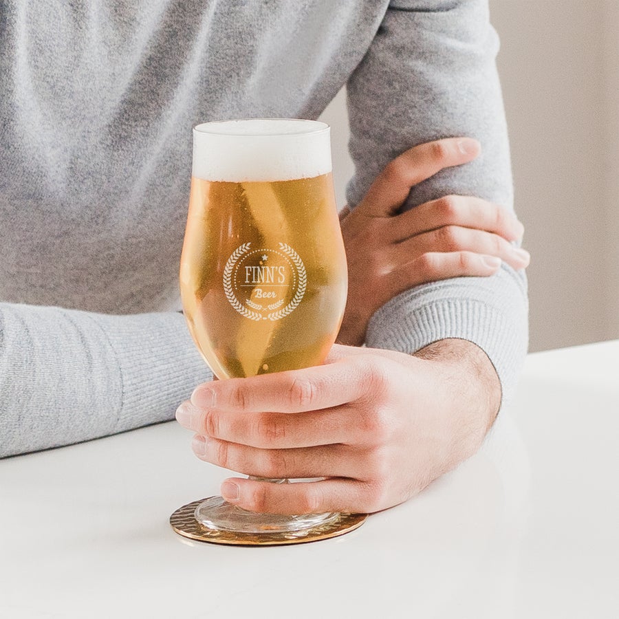 Biergläser mit Gravur Person hält ein Bierglas mit Gravur Finn's Beer personalisiert mit Namen und Datum, perfekt für Bierliebhaber.