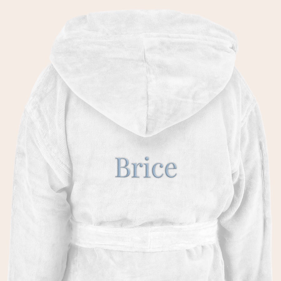 Peignoir enfant personnalisé Peignoir super doux pour enfant blanc avec capuche, brodé du prénom Brice en bleu.