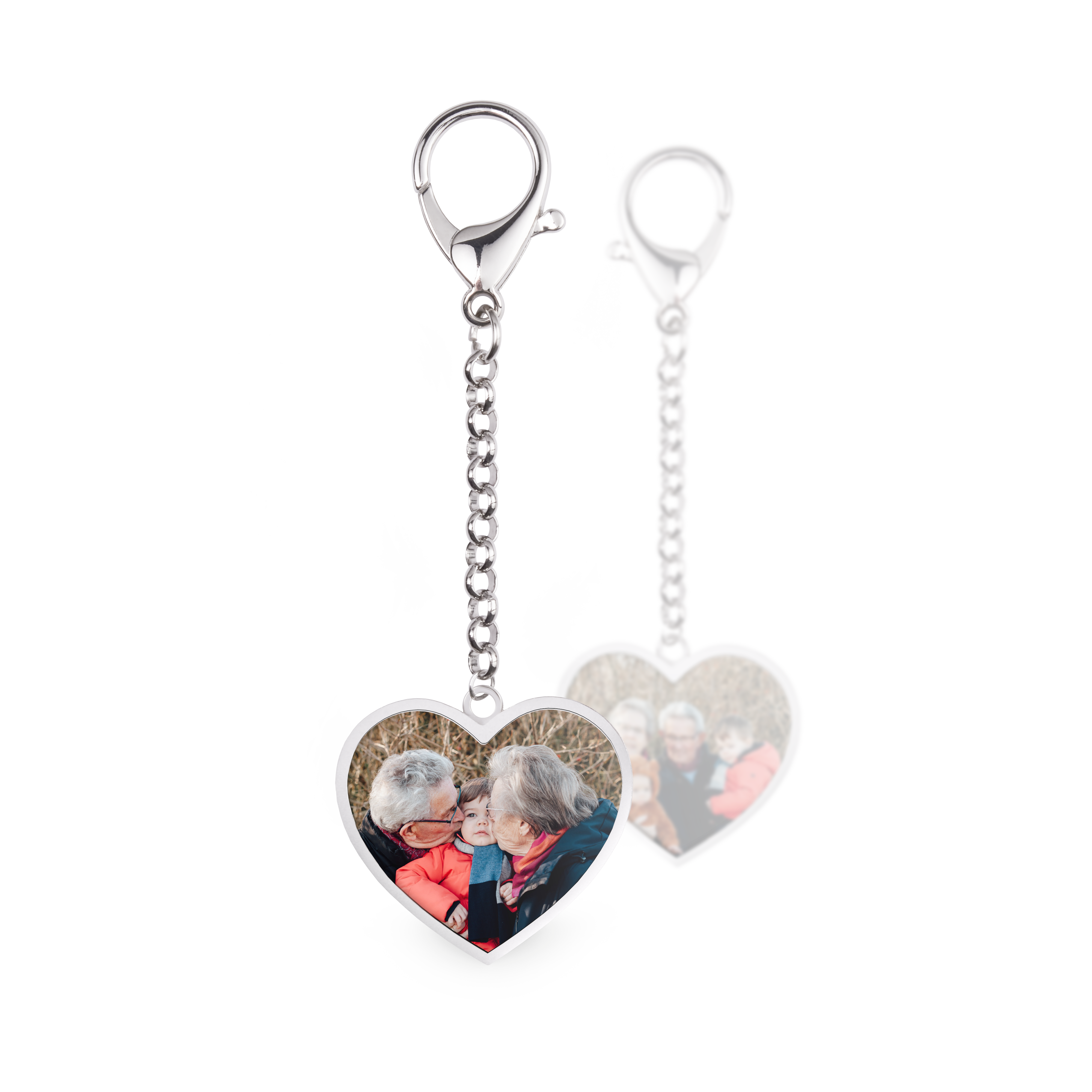 Two heart-shaped keyrings with chains and clasps. Each keyring is printed with a custom photo of a family.