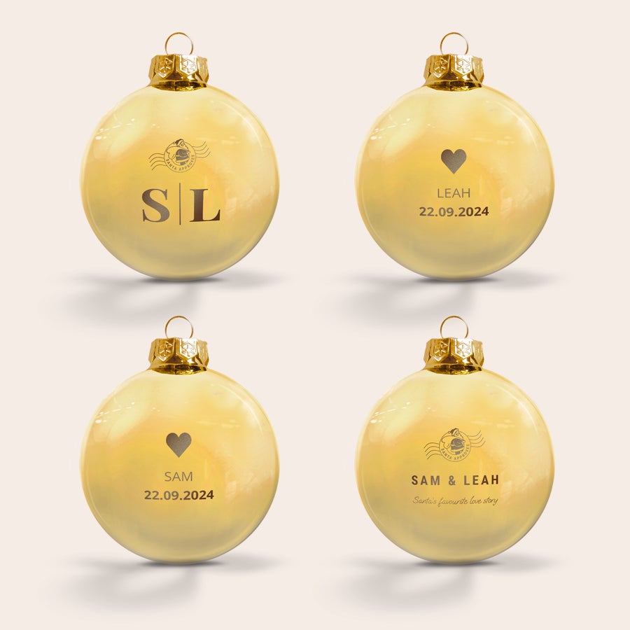 Glasjulkulor med namn En guldglĂ€nsande graverad julgranskula i glas med namn, initialer och datum som âLEAH 22.09.2024â.