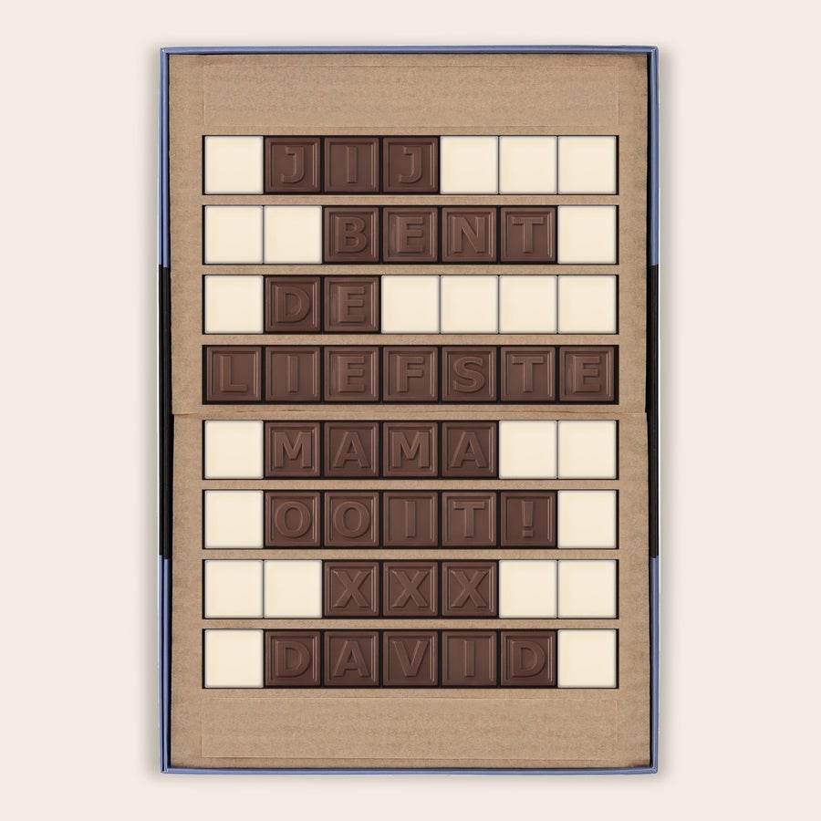 Chocotelegram Een persoonlijk chocotelegram met de boodschap "JIJ BENT DE LIEFSTE MAMA OOIT! XXX DAVID", gemaakt van melk- en witte chocolade blokjes, gepresenteerd in een luxe doos.