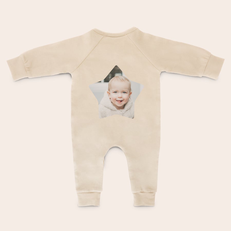 Costum de joacă pentru bebeluși Costum crem personalizat cu o fotografie imprimată a unui bebeluș zâmbitor, ideal pentru întinderea și lovirea picioarelor dolofane.
