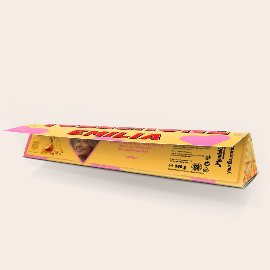 Toblerone Liebe Personalsieren Personalisierte Toblerone mit Name Emilia, Foto und der Aufschrift "Eine extra große Umarmung für dich. Sei extra gut zu dir selbst! Yannik", bedruckt mit Herzdesign.