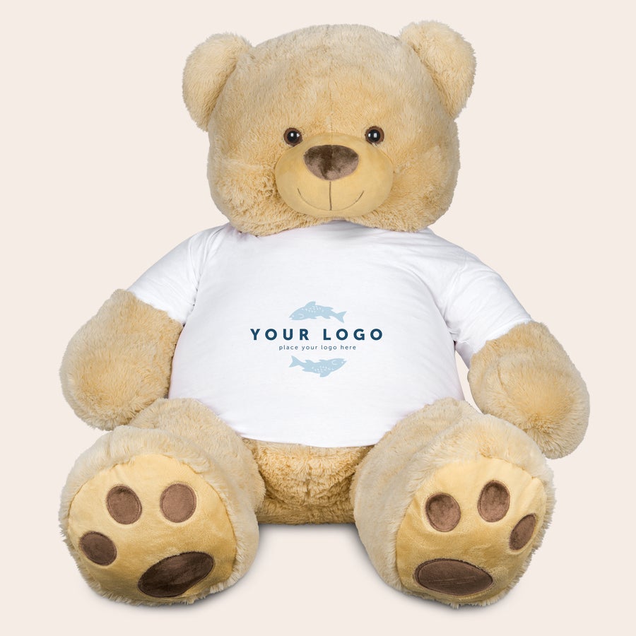 Kæmpe bamse med t-shirt med print - 130 cm! En kæmpe, lysbrun bamse iført en hvid t-shirt. T-shirten er trykt med teksten "YOUR LOGO" og har to blå fiskeikoner. Dejlige krammere med et personligt print.