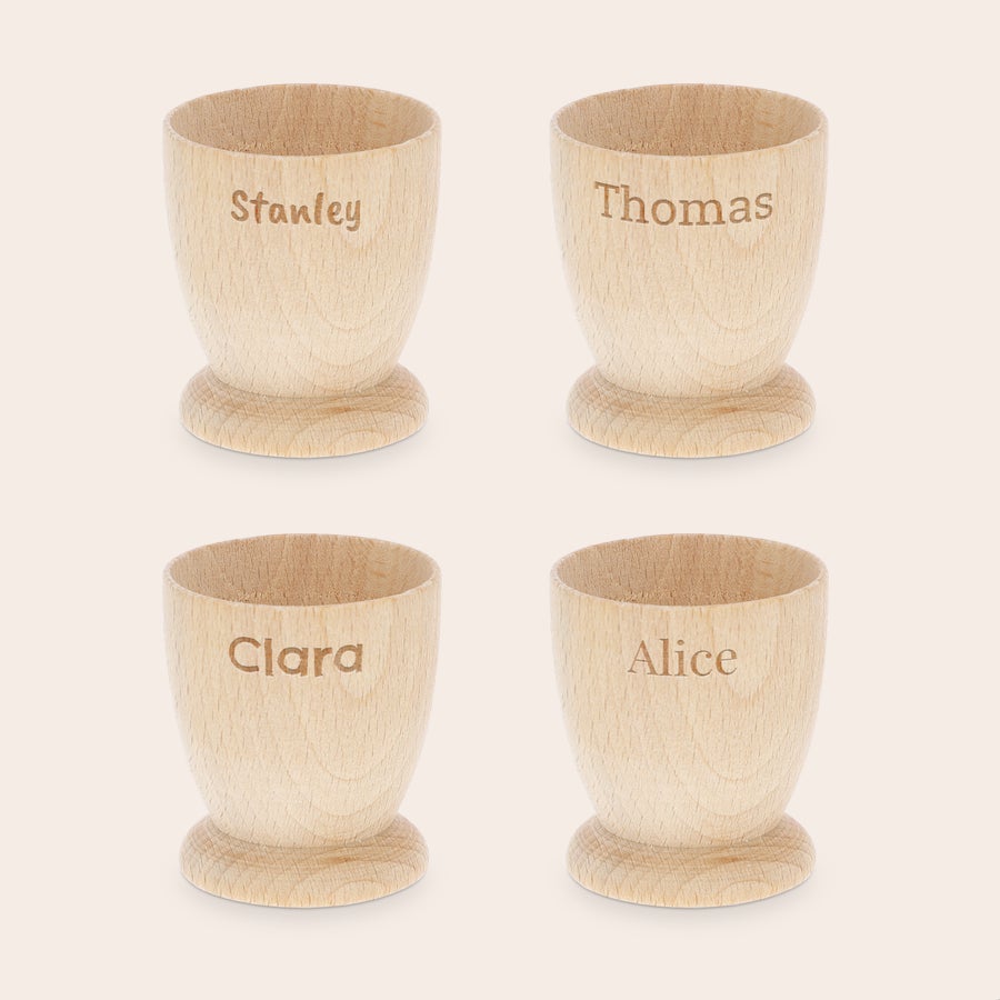 Personalizovaný pohár na vajcia Zapamätajte si raňajky pomocou prispôsobených pohárov na vajíčka z bukového dreva, gravírovaných menami Stanley, Thomas, Clara a Alice.