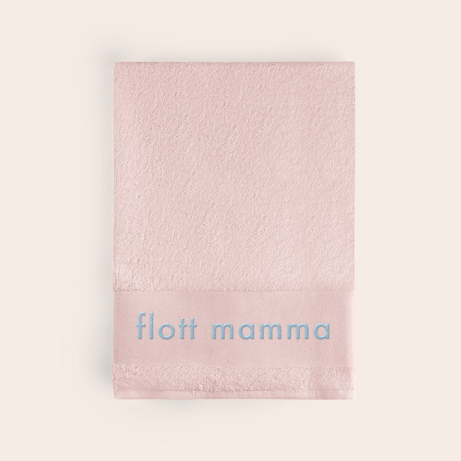 Håndkle med tekst Rosa håndkle med brodert teksten "flott mamma" i blått, perfekt som et brodert håndkle med navn.