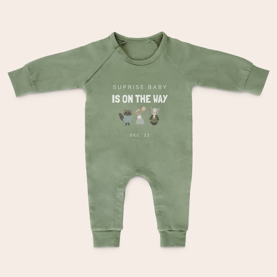 Babyplaysuit med tryk Grøn personlig playsuit med print af skovdyr og teksten Suprise baby is on the way og datoen dec 22. Stræk og spark med de buttede ben i en personlig playsuit.