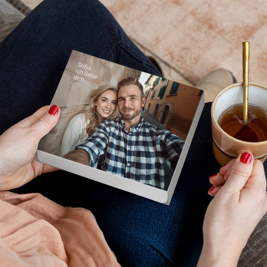 Merci Schokolade Personalisieren- 250 Gramm Personalisierte Merci Schokolade 250 Gramm mit Foto und Text Sofia Ich liebe dich, von Händen gehalten, neben einer Tasse Tee.