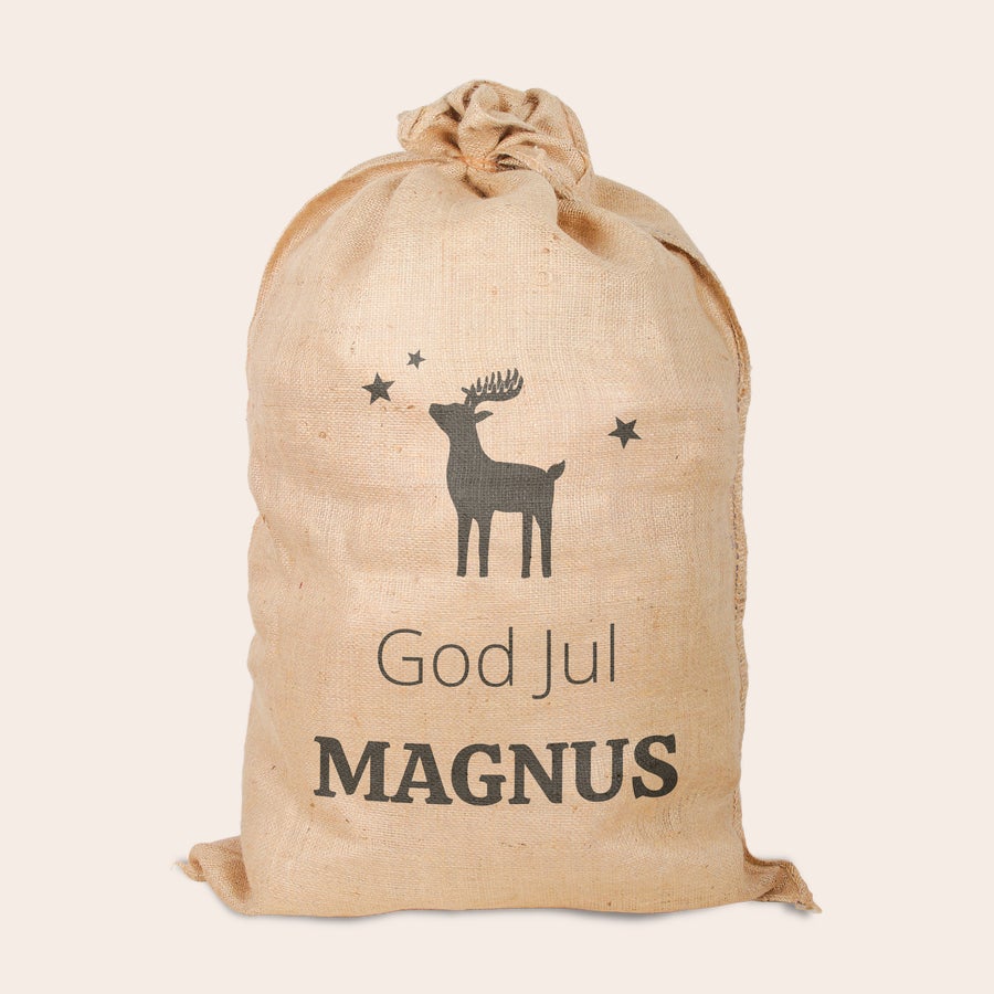 Personlig jute jul säck En unik jutsäck tryckt med en ren, God Jul och namnet Magnus.