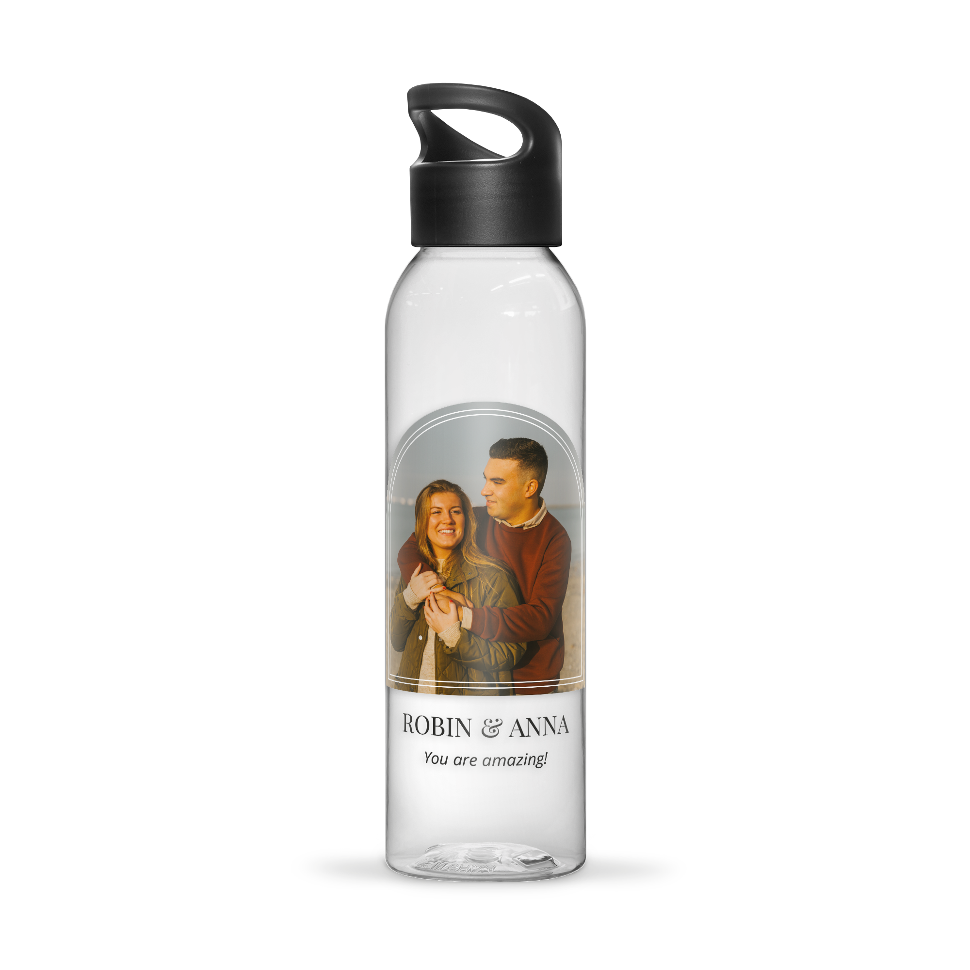 Garrafa de água transparente com tampa preta, personalizada com foto de casal e texto "Robin & Anna You are amazing!" impressos em cores.